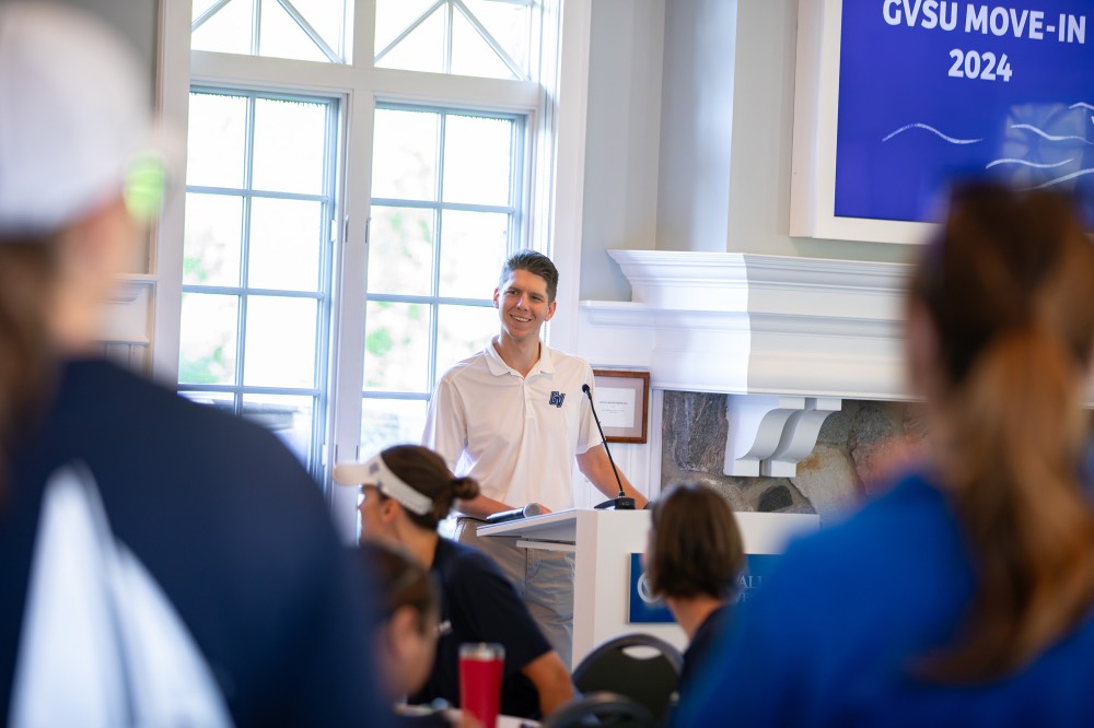 GV Employee smiles as he looks into crowd while standing at podium